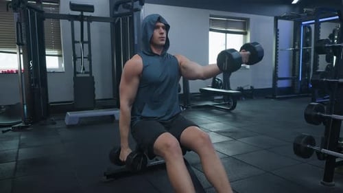 Sportsman Man Bodybuilder Doing Dumbbell Front Raises Shoulder Workout in Gym
