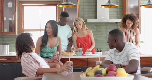 Un groupe d'amis diversifié se réunit dans une cuisine domestique moderne