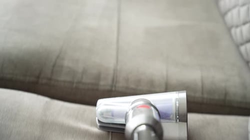 Cleaning a light gray sofa.