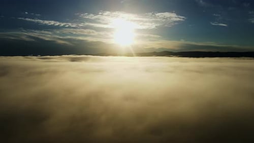 Flying Above the Clouds Against the Background of the Bright Sun