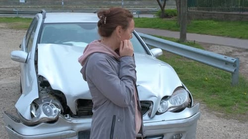 Woman Standing by Damaged Car After Accident