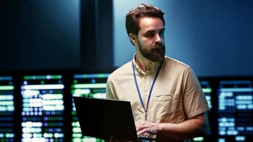 Man Typing On Laptop in Data Center