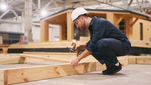 Worker Building Wooden Structure with Power Tool
