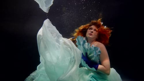 Pretty Middleaged Woman with Long Red Hair Swimming Alone in Dark Depth of Mysterious Lake