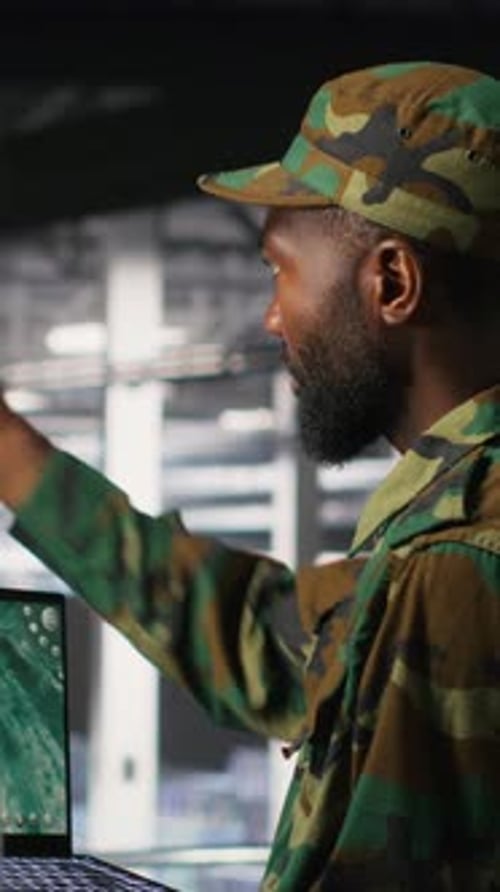 Vertical Video Military Experts in Data Center Reviewing Drone Surveillance Feed on Laptop