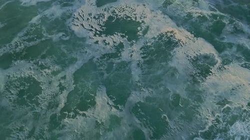 Ocean breaking waves on rocky coast. Drone tilt up shot. Ursa Beach, Portugal