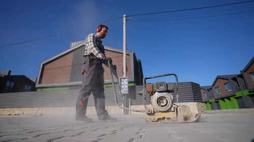 Man Uses Plate Compactor on Suburban Road