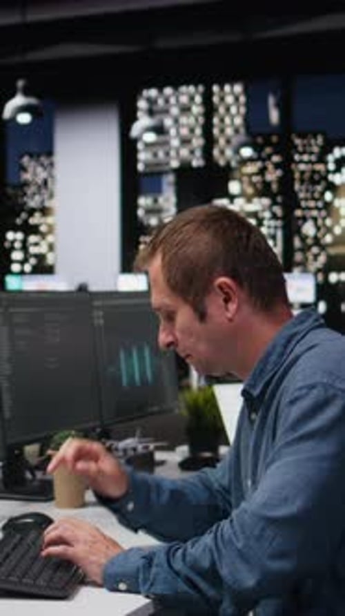 Man types at computer workstation in an office