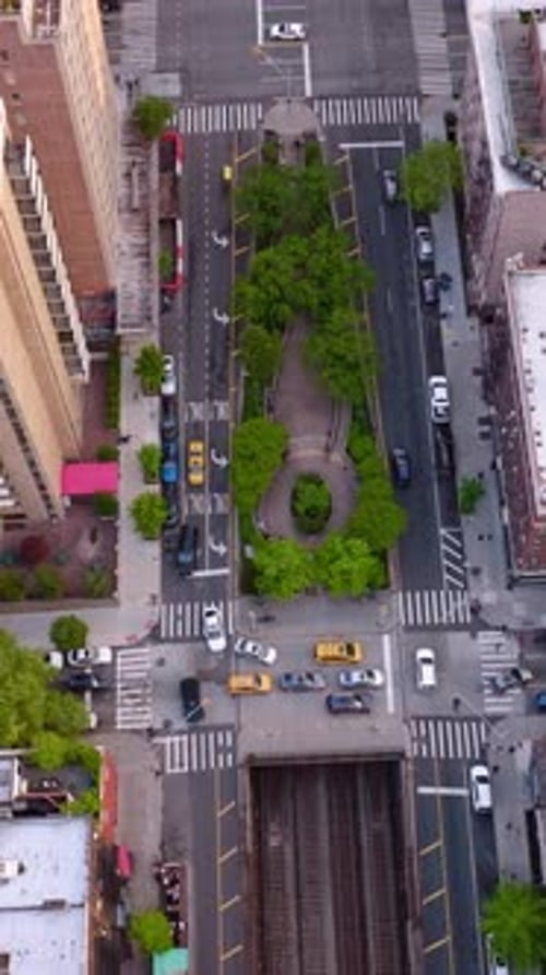 Various kinds of buildings in the district of New York. Busy streets with many cars going along.