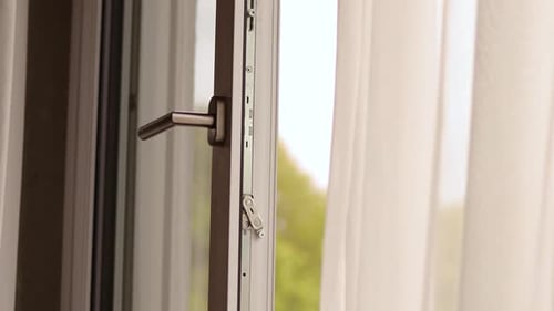 Une pièce ensoleillée dispose d'une fenêtre ouverte permettant à l'air frais de circuler à l'intérieur.