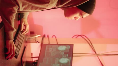Hooded Figure Typing on Keyboard at Desk