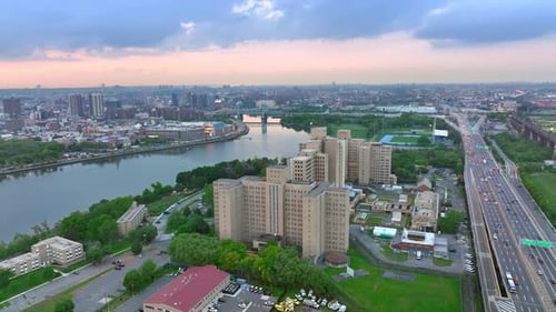 Smooth surface of the river flowing in New York. Busy multi-lane highway with numerous moving cars.