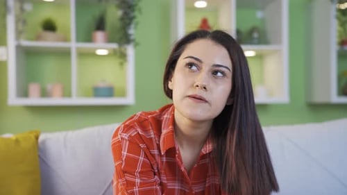 Jeune femme ennuyée, pensive à la maison, se sentant dépassée.