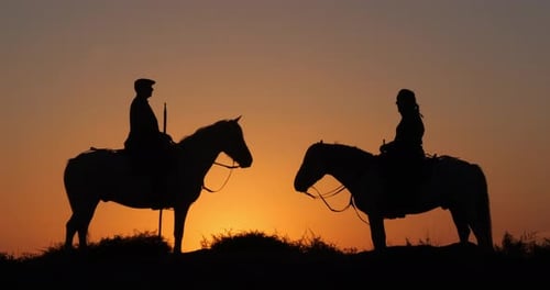 Mann und Frau auf einem Camargue- oder Camarguais-Pferd in den Dünen bei Sonnenaufgang