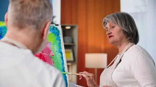 Woman Painting on Canvas with Friend Indoors