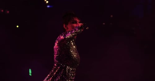 Woman Singing on Stage with Microphone at Night