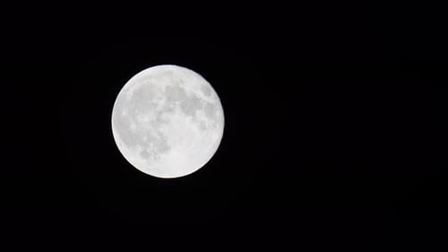 Stunning 4K video of a full moon filmed at night with telephoto lens.