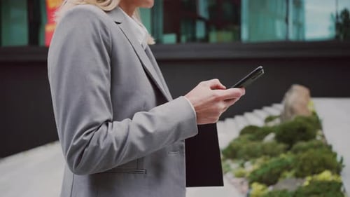 Young Adult Types on Phone outside Office Building