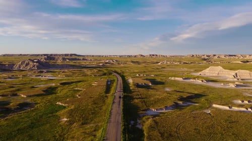 Goldenes Licht scheint auf der zerklüfteten Badlands Road in atemberaubender Luftaufnahme