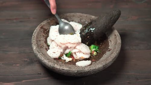 Hands Preparing a Spicy Asian Dish with Crackers