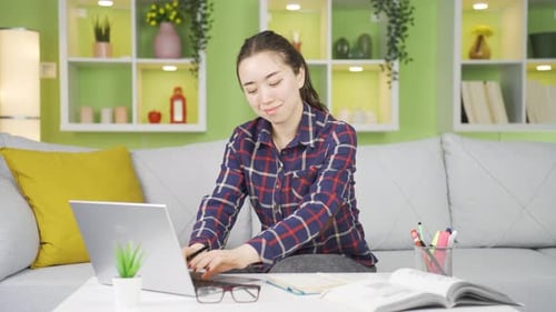 Woman Works on Laptop at Home