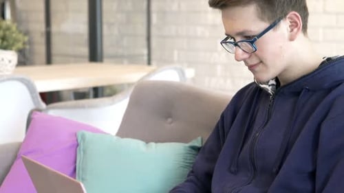 Teenager Typing on Laptop Indoors During the Daytime