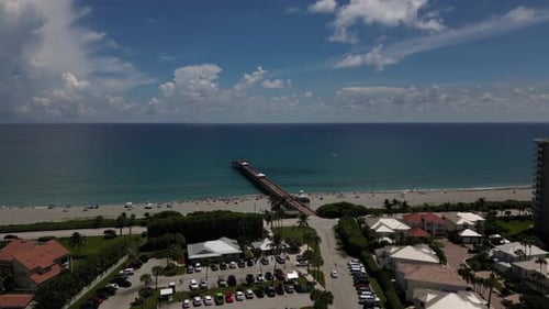 Imagens aéreas de Drone de uma cidade costeira e um píer estendido sobre o Oceano Atlântico na Flórida.