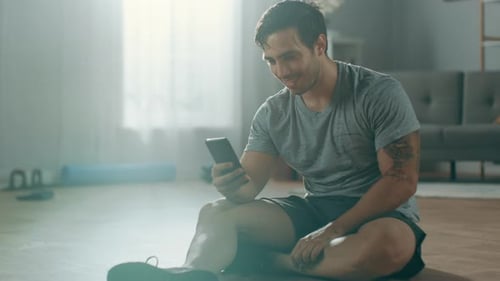 Athletic Man Using Phone Indoors After Workout