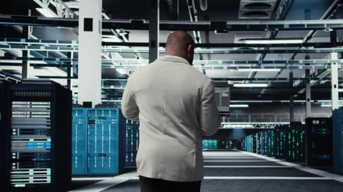 Data Center Technician Using Laptop to Manage Software Updates