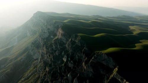 High Mountains in the Fog The Green Hills are Illuminated By the Contrasting Sun Aerial Photography