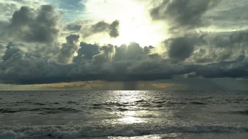 Beautiful Sea Sunset with Thick Clouds and Waves on the Water