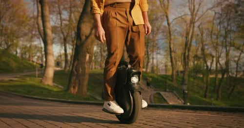 Senior Man Riding Electric Mono Wheel Gyro Scooter Personal Electrical Transport in Park People Use