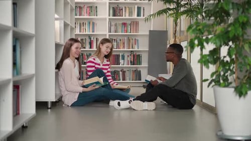 Happy Friends Sit on Floor in Public Library