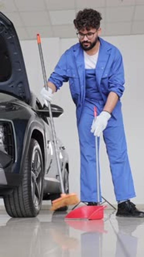 Professional Auto Mechanic Cleaning the Garage Floor