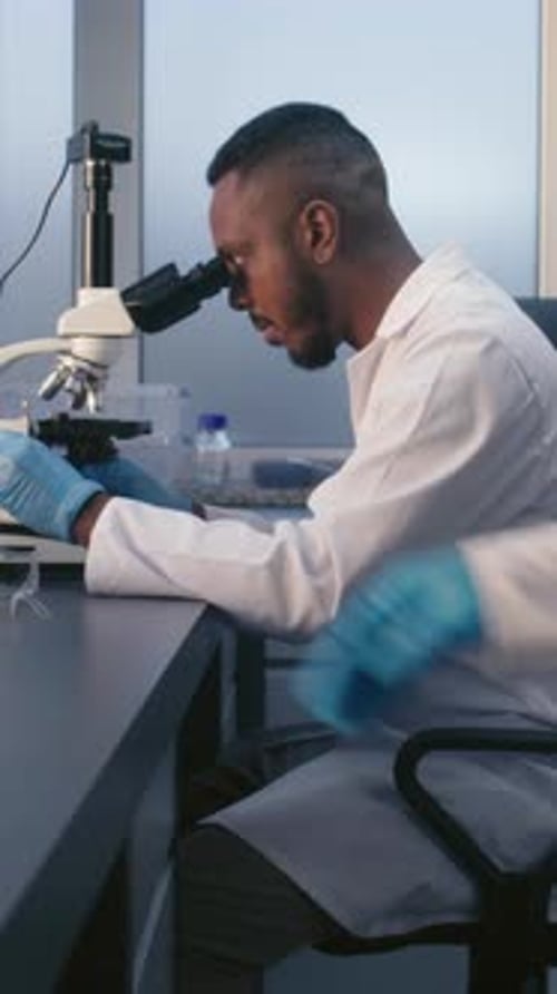 Scientist Using Microscope in Medical Laboratory