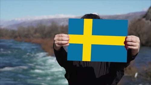Person Holding Banner With Flag Of Sweden