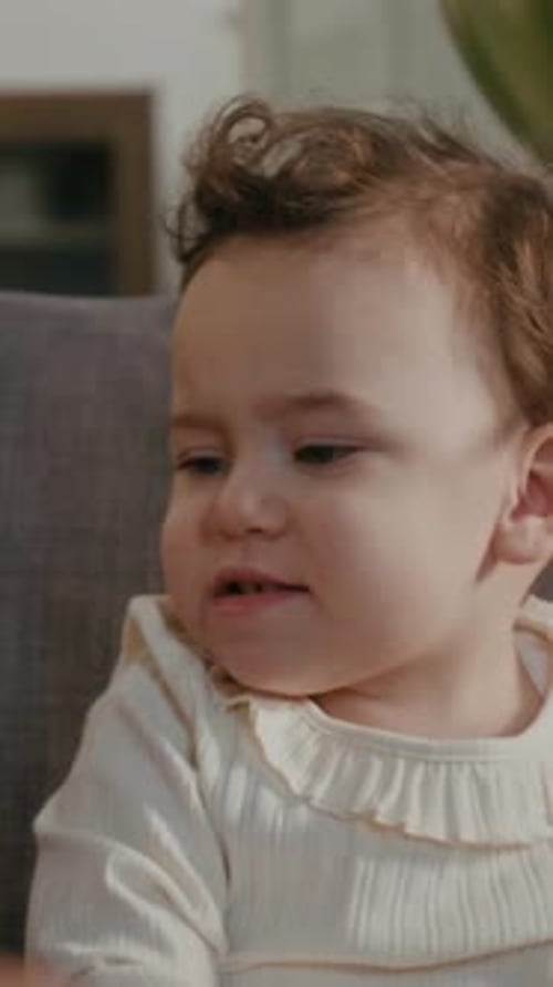 Close-up of Little Girl Holding Party Cap Posing for Smartphone Camera with Mom