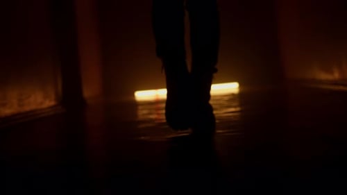 Silhouette of a Person Walking in Dark Tunnel