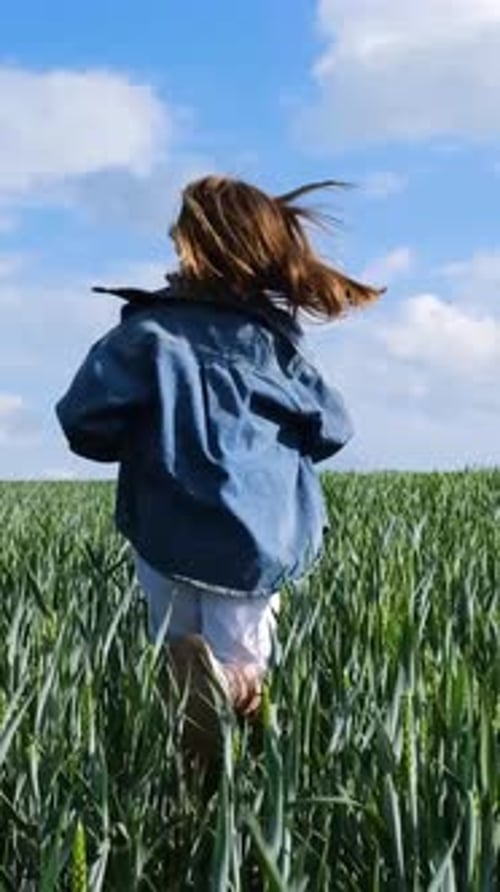 A Cheerful Child Joyfully Runs Through the Lush Wheat Field Embracing Nature with Happiness and