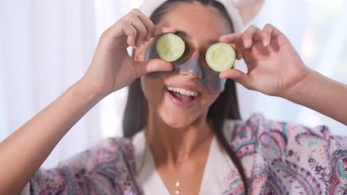Funny Smiling Spa Woman with Fresh Facial Mask Hold Cucumbers