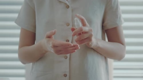Close up shot of woman applying a sanitizer gel against Corona Virus Disease on her hands.