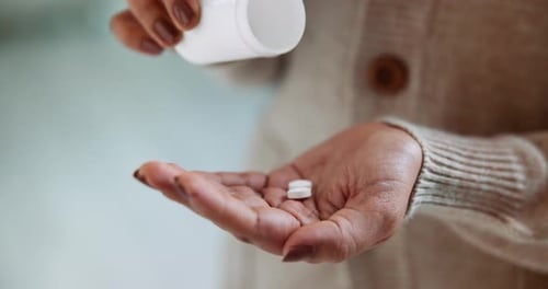 Hand Dispensing Two White Pills into Palm