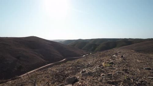 Barren dry hills and harsh landscape in Algarve, Portugal - Push in Crane up shot