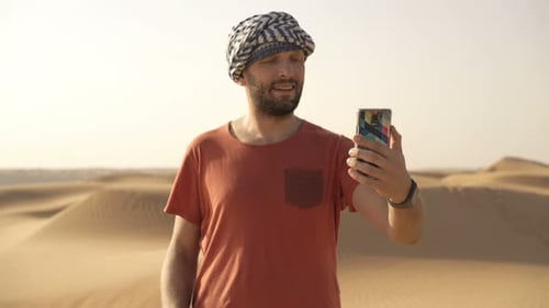 Young Man Taking Selfie Photo with Cellphone on Desert 30s