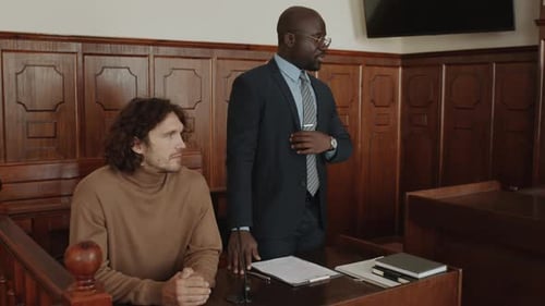 Black Male Lawyer Defending Caucasian Young Man at Court Trial