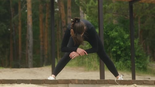Brunette Woman Exercising and Stretching Outdoors