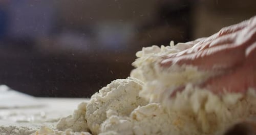Hands Kneading Dough Ingredients in a Kitchen