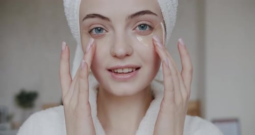 Woman Applying Eye Masks in Home Setting
