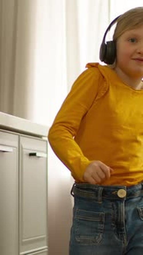 Caucasian Girl Child Daughter Kid Dancing at Home Wearing Headphones Wireless Earphones Audio
