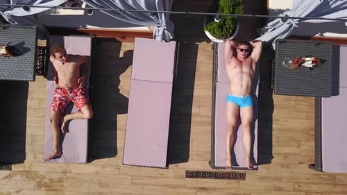 Aerial View of Men Relaxing by Pool